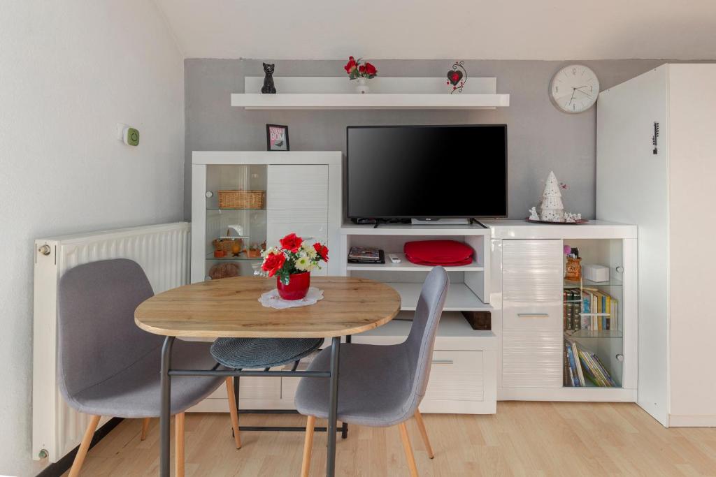 a dining room with a table and chairs and a tv at Oddih ob Krki in Škocjan