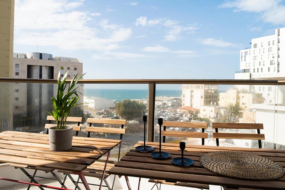 a balcony with a table and benches on a balcony at Sublet TLV 270 in Tel Aviv