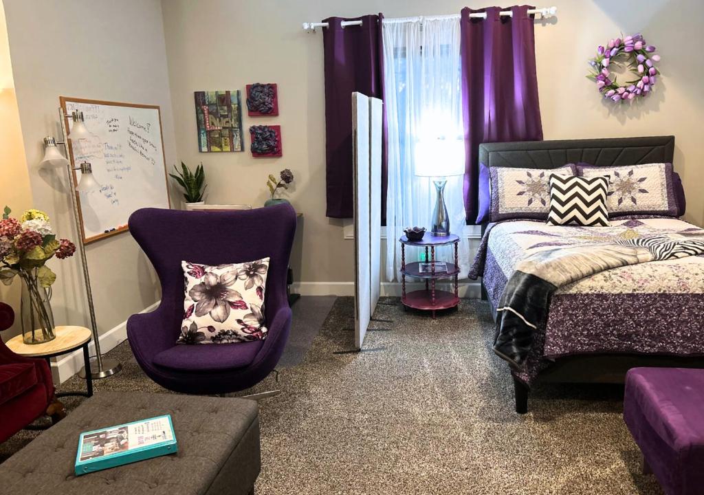 a bedroom with a bed and a purple chair at VIP Suites for Business Women, Nurses, College Moms Traveling to Indianapolis in Indianapolis