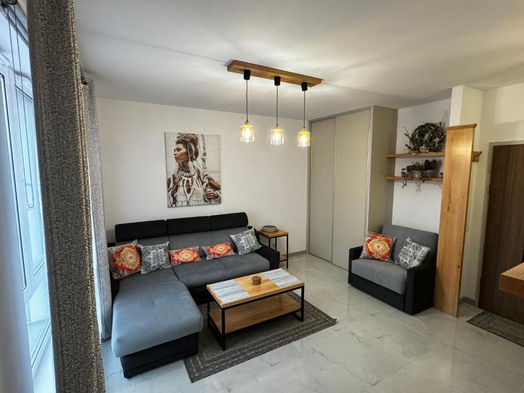 sala de estar con sofá y mesa en Apartament Moderato en Starogard Gdański