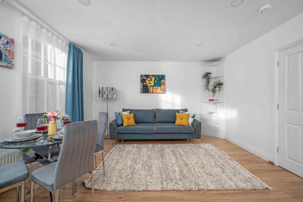 a living room with a blue couch and a table at Brick Lane, London - Lovely One Bedroom Apartment in London