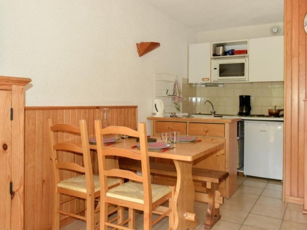 eine Küche mit einem Holztisch und Stühlen in der Unterkunft Studio Montgenèvre, 1 pièce, 4 personnes - FR-1-266-130 in Montgenèvre