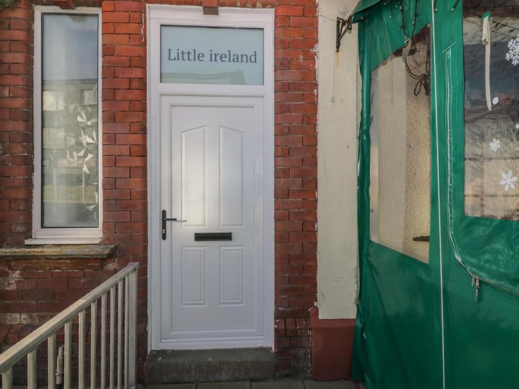 a white door on the side of a brick building at Little Ireland in Stranraer