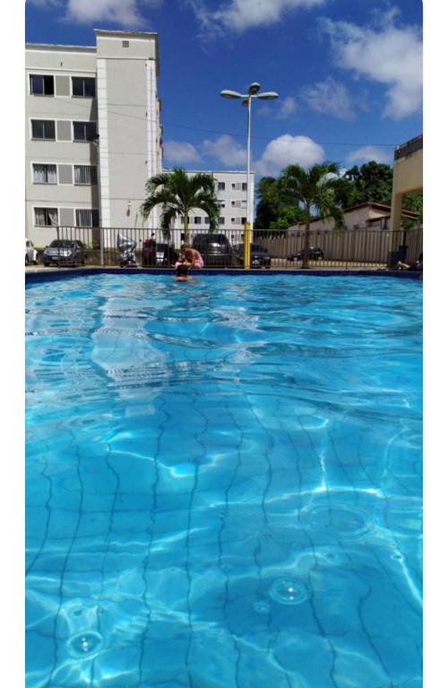 uma grande piscina de água azul em frente a um edifício em Apartamento do Sossego em São Luís