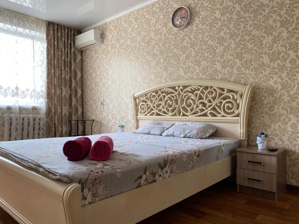 a bedroom with a bed with red pillows on it at 1 комн квартира в 6 мкр (Кунаева) in Uralsk