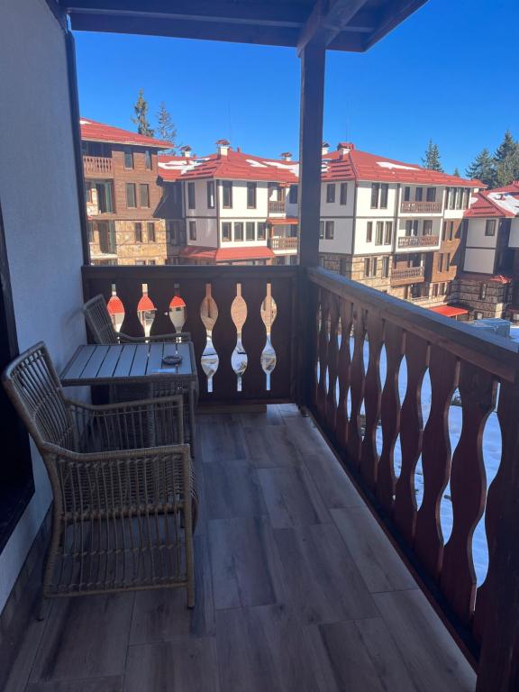 - un balcon avec une table, des chaises et des bâtiments dans l'établissement Grand resort luxury apartment, à Pamporovo