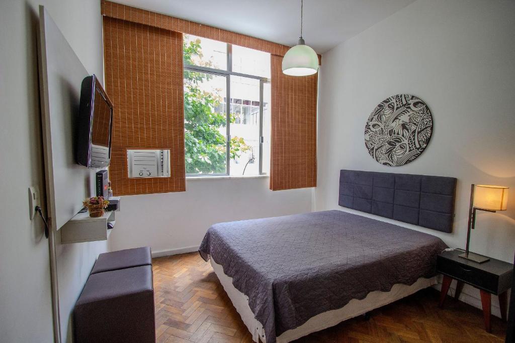 1 dormitorio con cama y ventana en COPACABANA - Lindo apartamento na quadra da praia, en Río de Janeiro