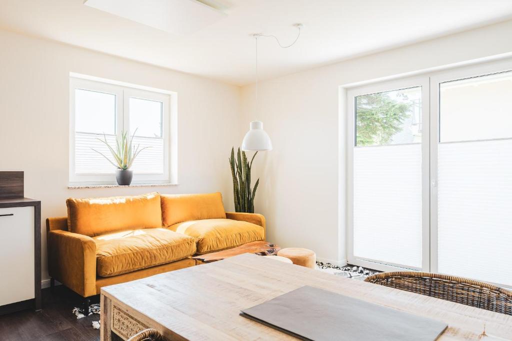 Dünenquartier Apartment 15 في زنغست: غرفة معيشة بها أريكة وطاولة