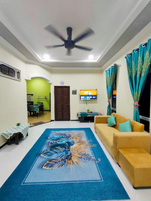 a living room with a couch and a ceiling fan at Raihan Homestay B Kubang Kerian,Free Wifi in Kota Bharu