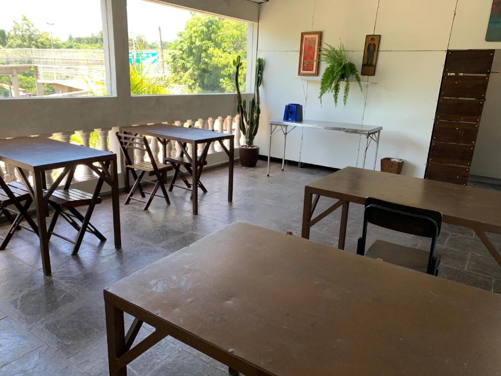 four tables and chairs in a room with a window at Hotel economic eldorado in Sorocaba