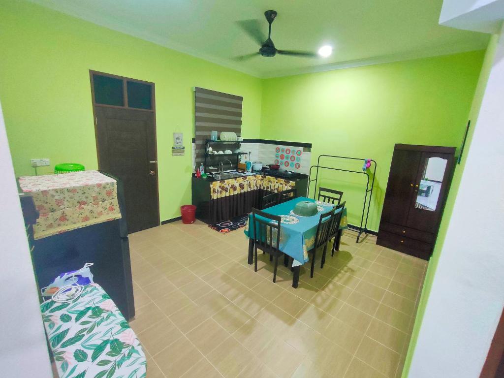 een kamer met groene muren en een tafel en stoelen bij Raihan Homestay B Kubang Kerian,Free Wifi in Kota Bharu