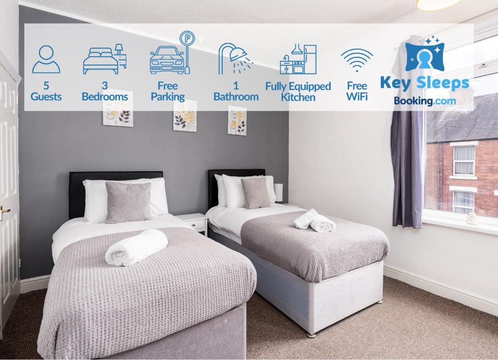 - 2 lits dans une chambre avec des panneaux sur le mur dans l'établissement Spacious 3 Bed House With Free Parking, à Doncaster