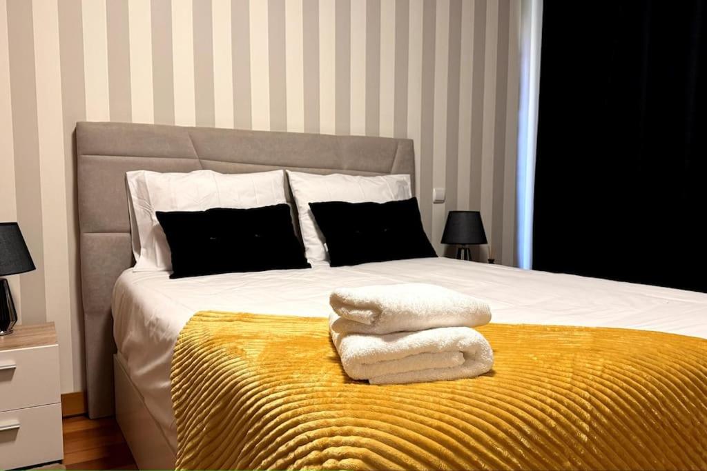 uma cama com duas toalhas num cobertor amarelo em By the Sea IV - Cosy flat no Funchal