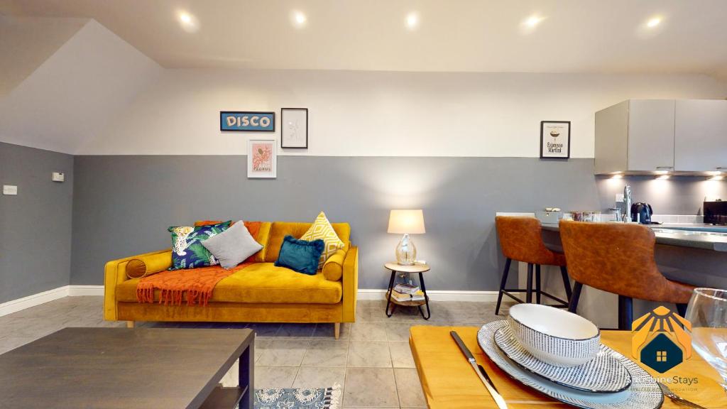 sala de estar con sofá amarillo y cocina en Central 2 Bed Flat with Parking en Cardiff