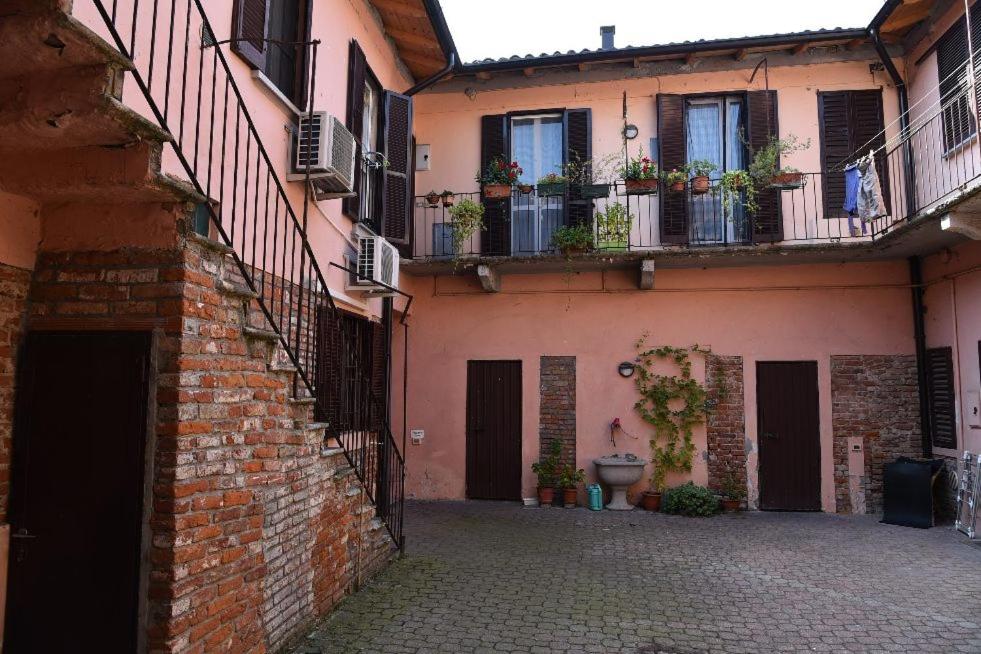 un vicolo in un vecchio edificio con balconi e piante di B&B Pavia Centro Ticino a Pavia