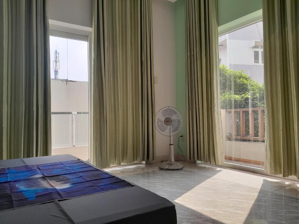 a bedroom with a fan and a large window at QV Home in Ho Chi Minh City