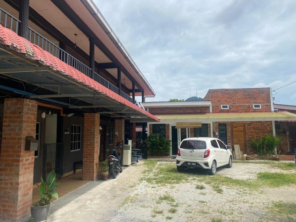 una macchina bianca parcheggiata di fronte a un edificio di OYO 90910 Homestay D Lalang Inn a Kuah