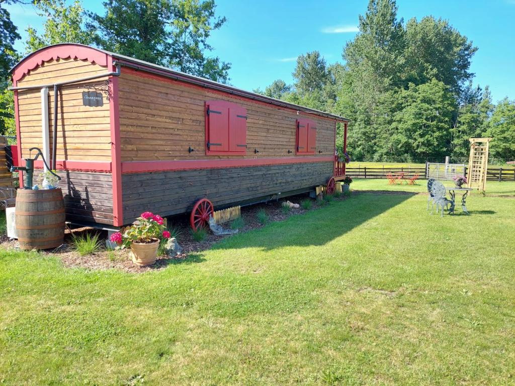 een houten treinwagon in een veld bij Margaux B&B Babbita in Stokrooie