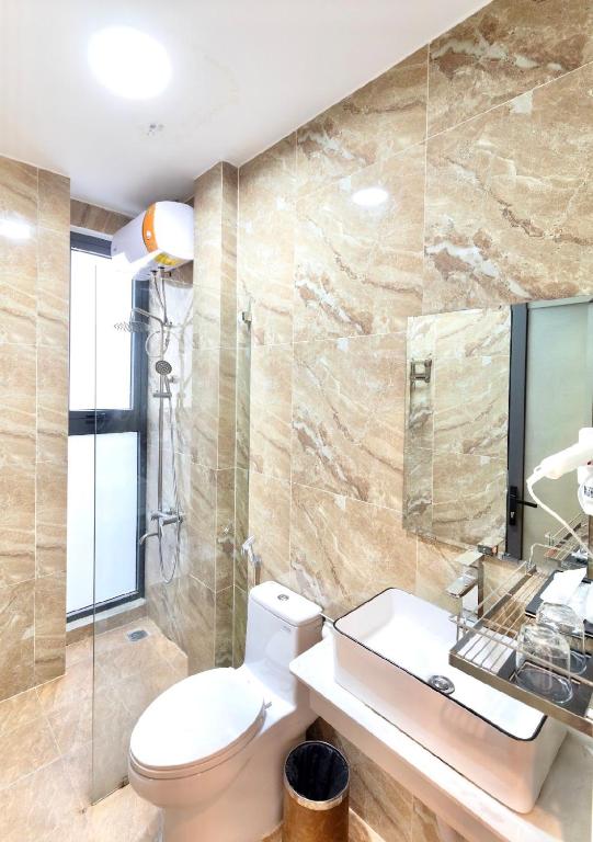a bathroom with a toilet and a sink at TTR Midtown View Hotel in Da Lat