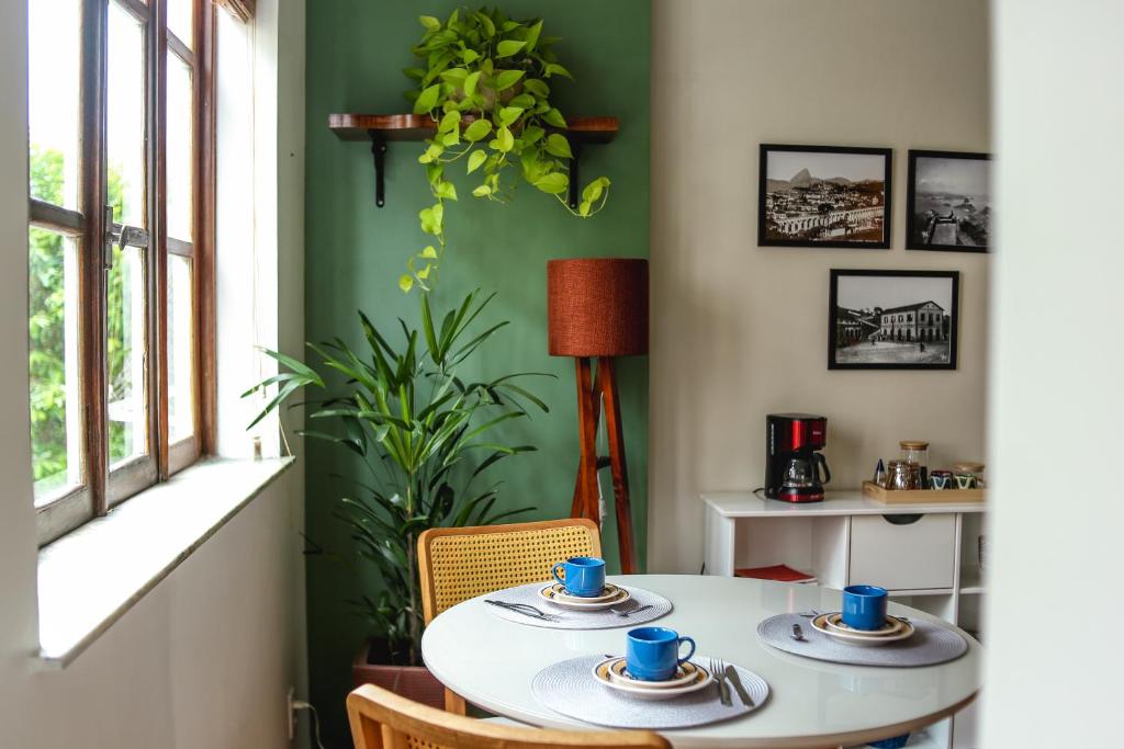 stół w pokoju z zieloną ścianą w obiekcie Aconchego no coração de Santa Teresa w mieście Rio de Janeiro