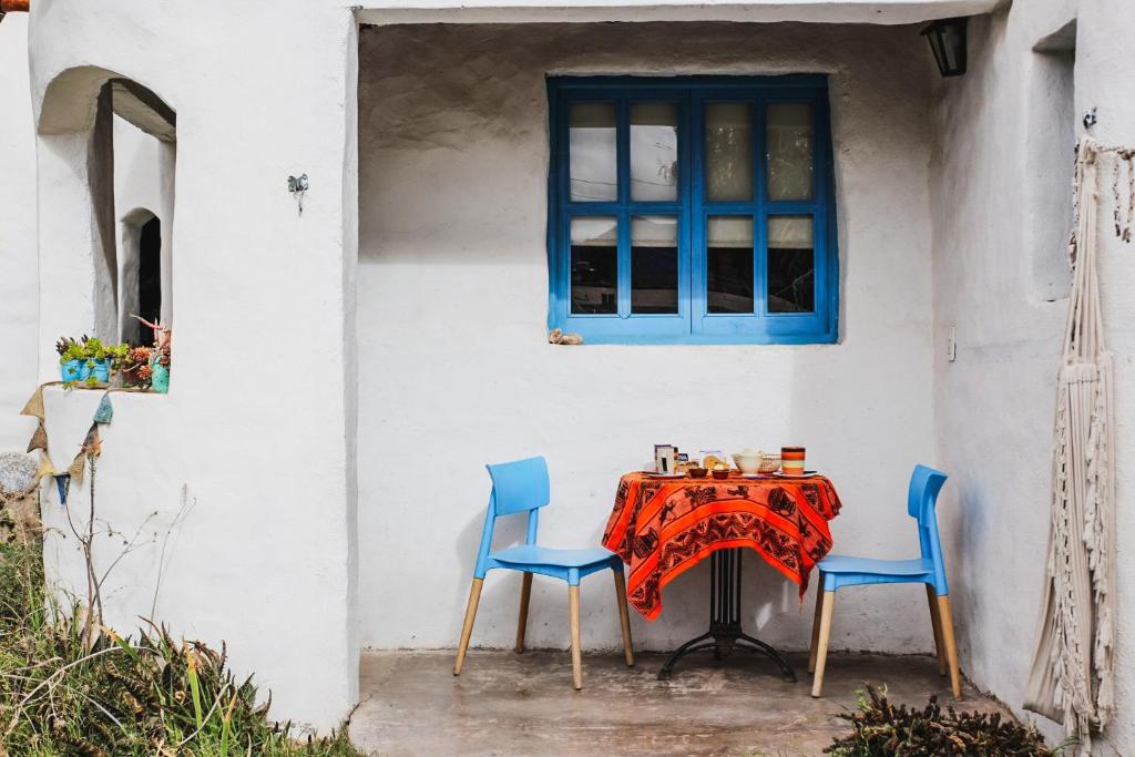 a table with two chairs and a blue window at La Casa de Vero in Cachí