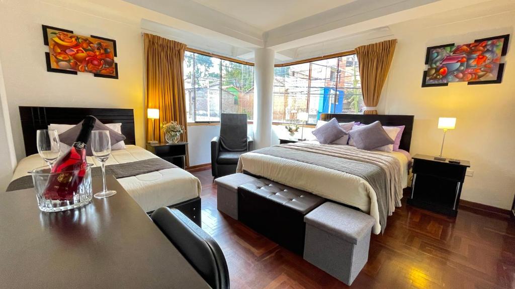 Allincay Cusco Apart Hotel في كوسكو: غرفة فندقية بسريرين وطاولة وكراسي