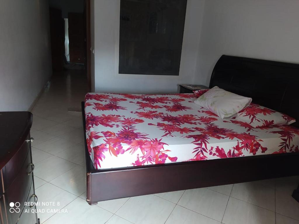 Schlafzimmer mit einem Bett mit einer roten und weißen Decke in der Unterkunft Nouvel Appartement Hamria in Meknès
