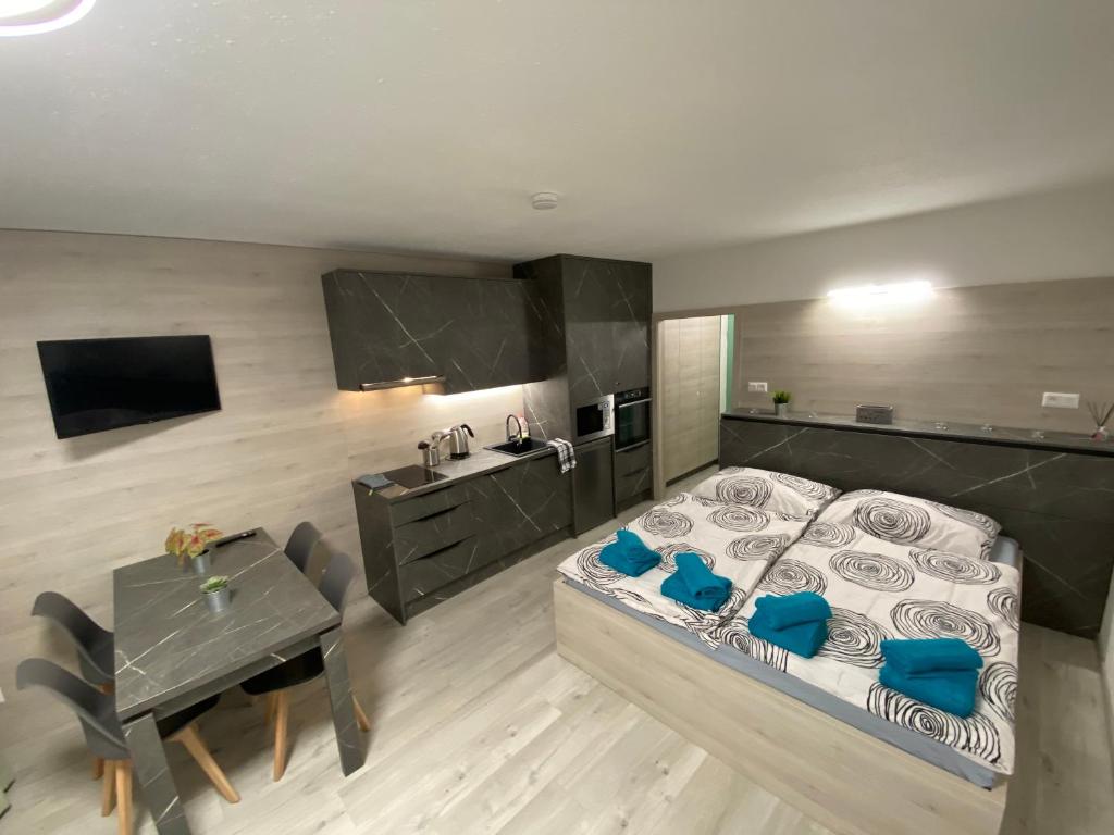 Un dormitorio con una cama y una mesa y una cocina. en Apartmány Almberg Mitterdorf, en Mitterfirmiansreut