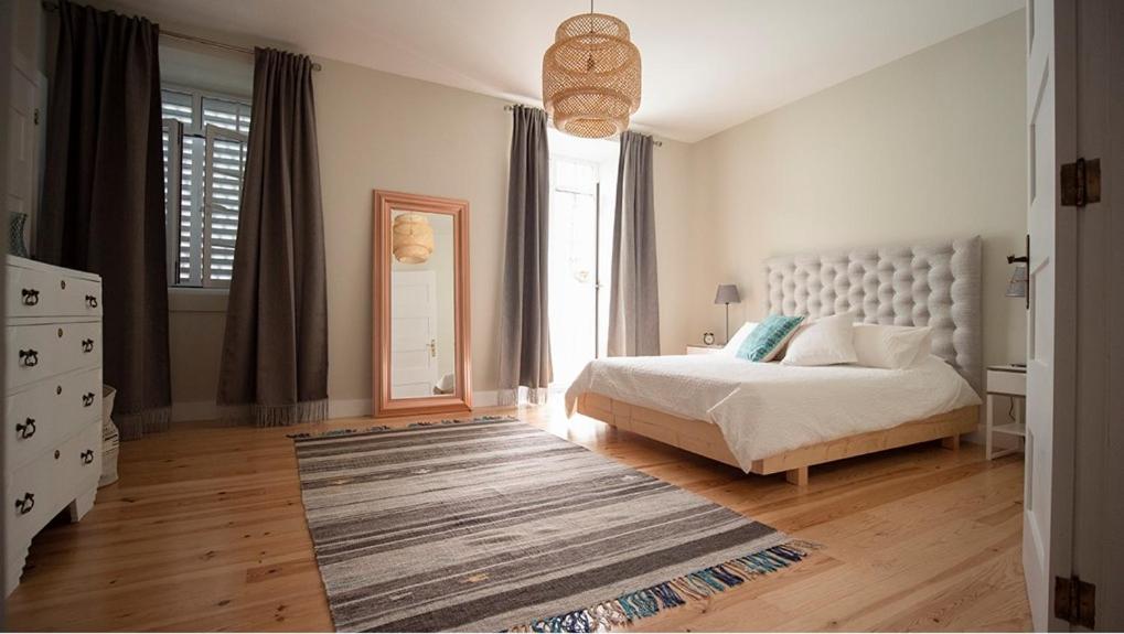 um quarto com uma cama e uma grande janela em WelcomeBuddy - Casa Memorial Miguel Faial em Ponta Delgada