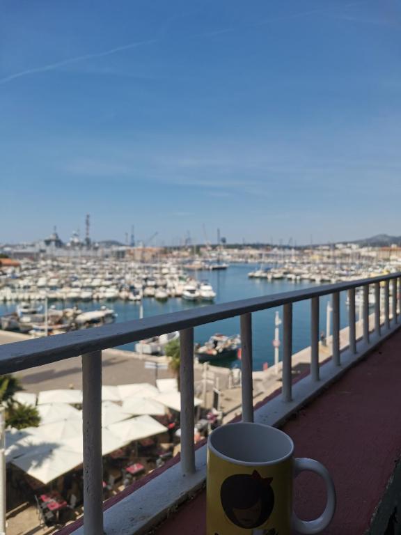 - une tasse de café assise sur un balcon avec un port de plaisance dans l'établissement Marina dream, à Toulon