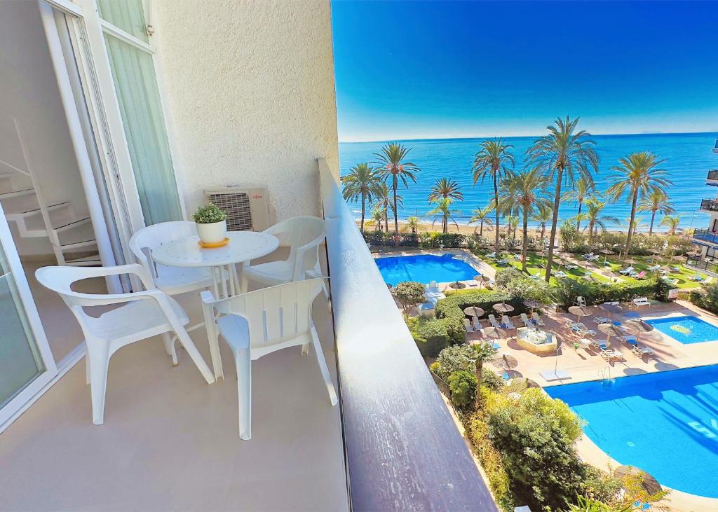 マルベーリャにあるSkol 302 Super One-bedroom Duplex with Sea Viewsの海の景色を望むバルコニー(テーブル、椅子付)