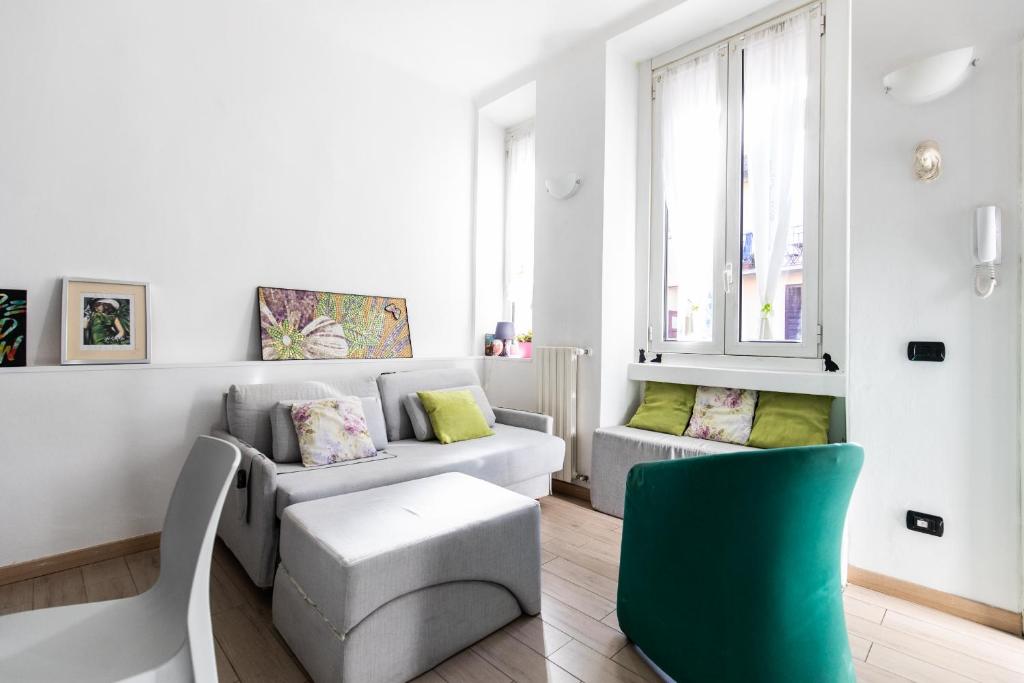 a living room with a couch and a green chair at Rogoredo - Exclusive Apartment in Milan