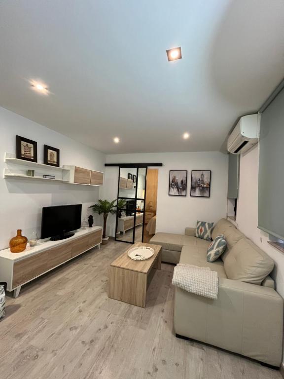 een woonkamer met een bank en een tafel bij Apartamento Azonaicas in Córdoba
