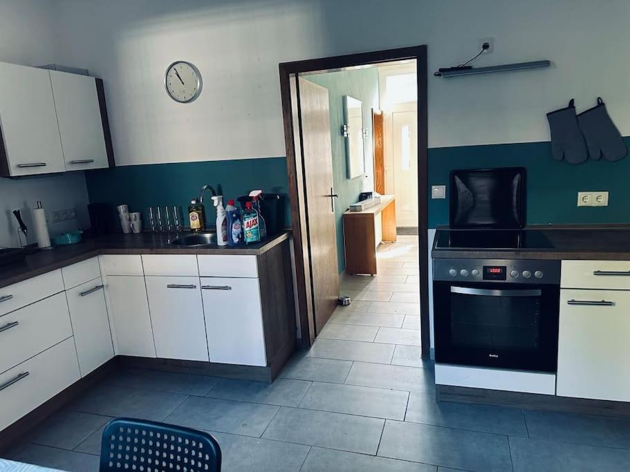 a kitchen with white cabinets and a black oven at StadtHOUSE Bentheim Viel Platz für Gruppen in Bad Bentheim