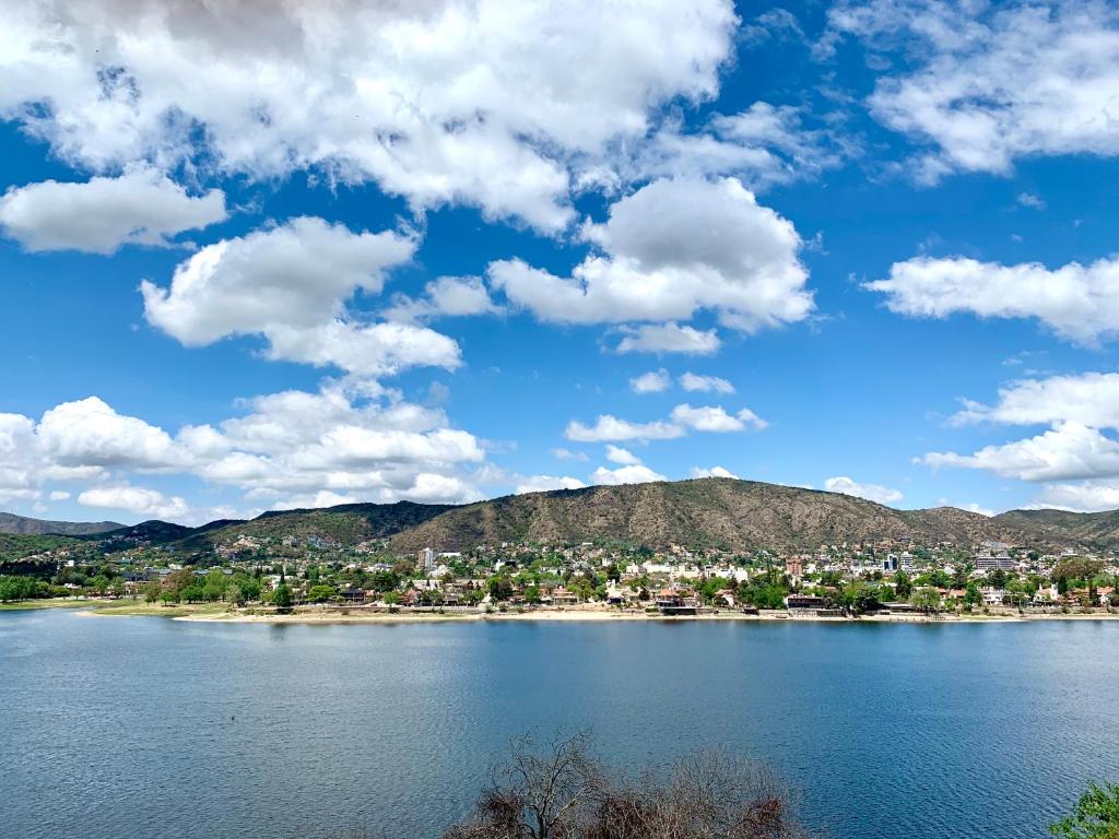 uma vista para um lago com uma cidade e montanhas em casas lago san roque em Villa Carlos Paz