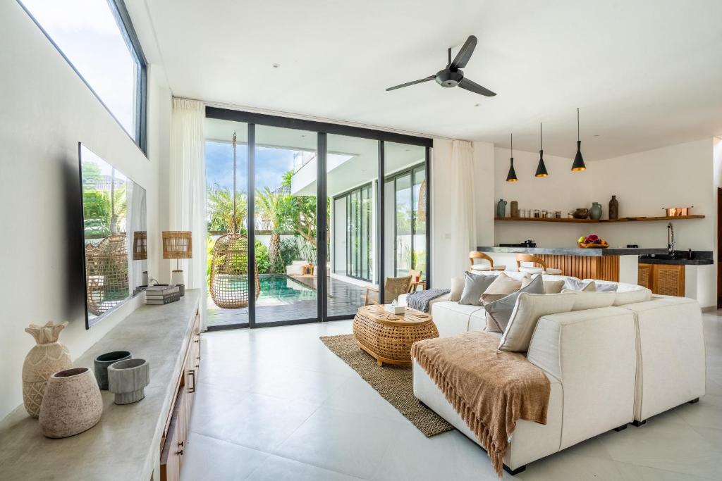 a living room with a white couch and a table at Ozkar Villa Canggu in Canggu