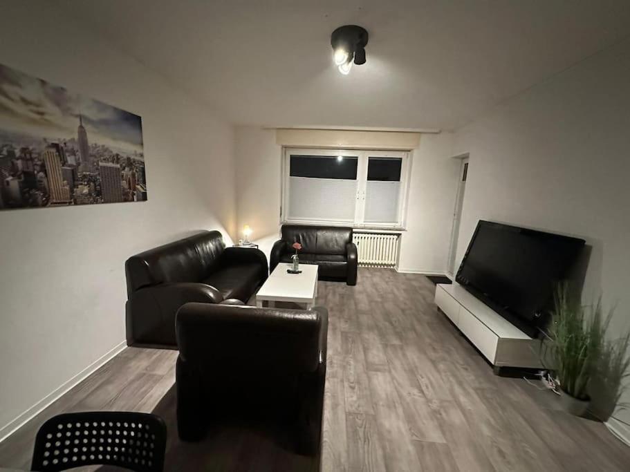 ein Wohnzimmer mit Ledermöbeln und einem Flachbild-TV in der Unterkunft Personalunterkunft in Rheine mit Balkon in Rheine