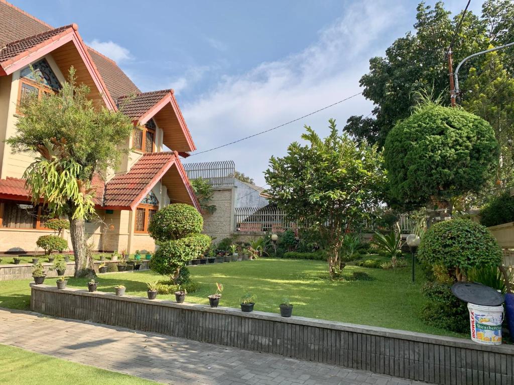 a house with a lawn in front of it at Villa Nuansa Alam in Lembang