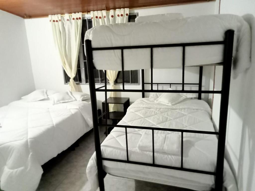 a bedroom with two bunk beds and a window at Hospedaje Cristiano Almagor in Bogotá