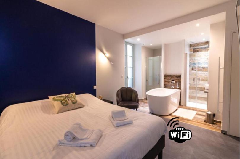 a bedroom with a large bed and a bath tub at Sarlatitude, Studios &amp; Chambres in Sarlat-la-Canéda