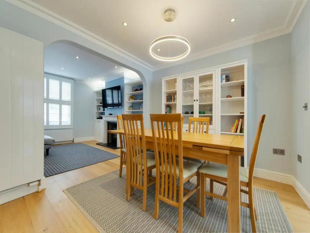 a dining room with a wooden table and chairs at Pass the Keys Centrally located modern and spacious 3 Bed terrace in Cambridge