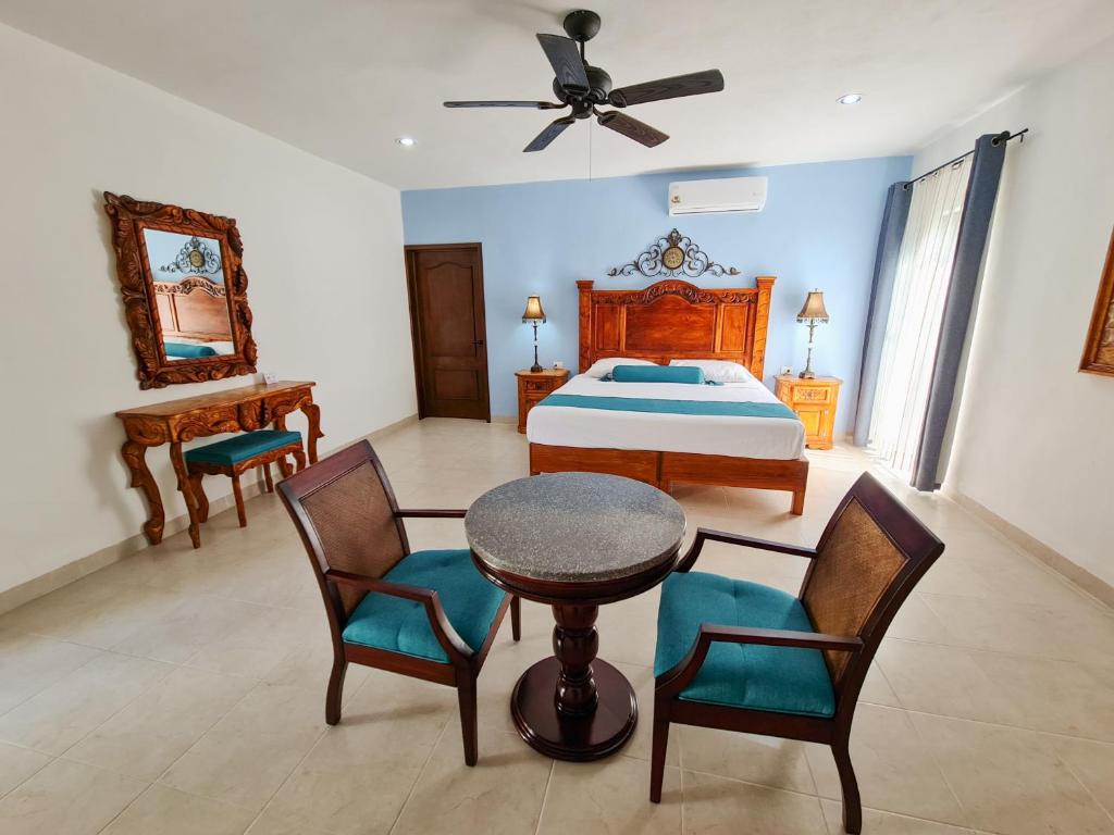 a bedroom with a bed and a table and chairs at Hotel Fundadores in Valladolid