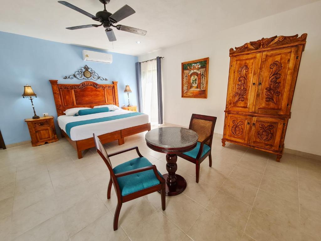a bedroom with a bed and a table and chairs at Hotel Fundadores in Valladolid
