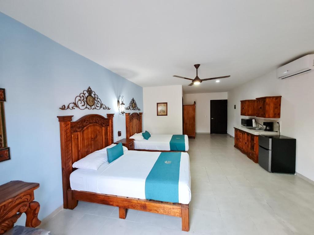 a bedroom with two beds and a kitchen at Hotel Fundadores in Valladolid
