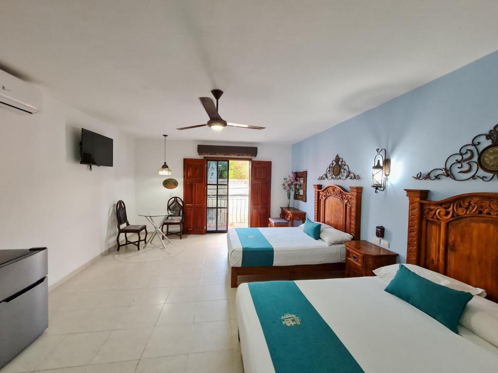 a hotel room with two beds and a television at Hotel Fundadores in Valladolid