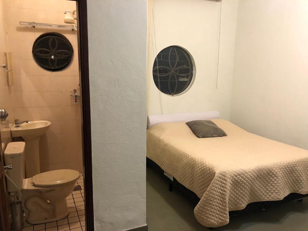 a small room with a bed and a toilet at Belo Horizonte - Espaço reservado para 5 pessoas in Belo Horizonte