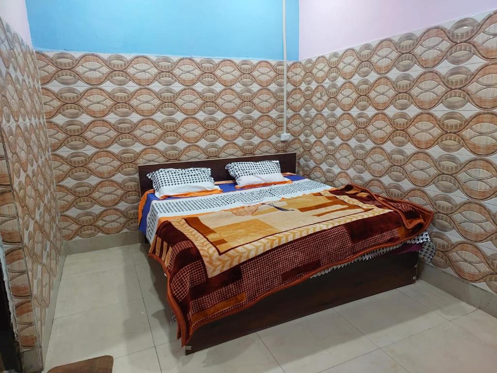 a bed in a room with a wall at Annu Bhai sewa sadan in Mathura