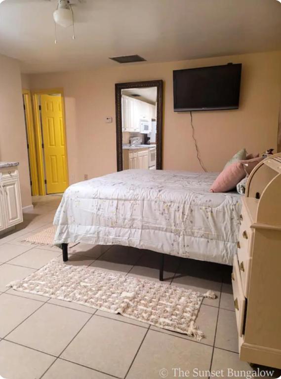 a bedroom with a bed and a flat screen tv at The Sunset Bungalow in Naples
