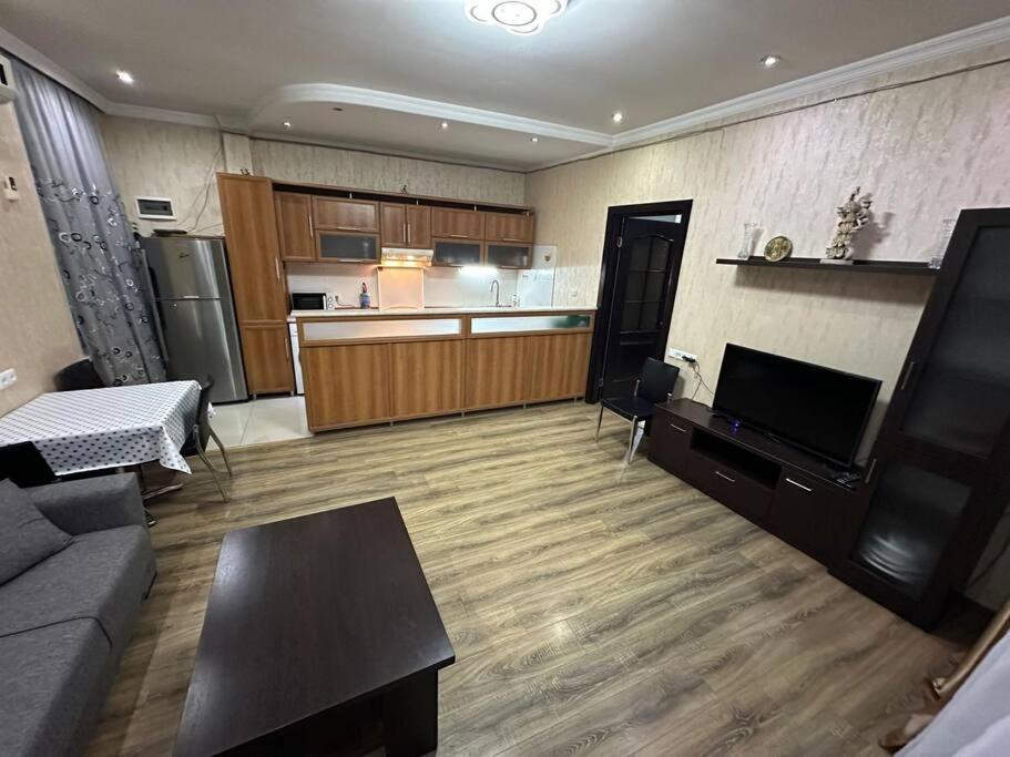 a living room with a couch and a kitchen at Comfortable House the city centr in Kutaisi