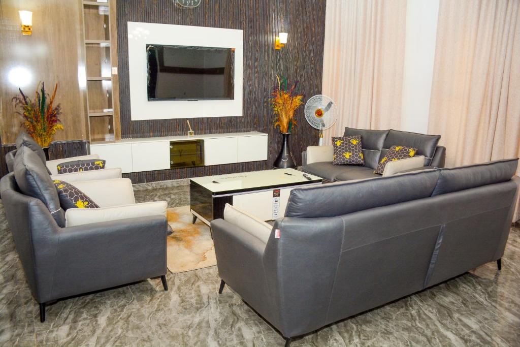 sala de estar con 2 sofás y TV en Dabras Homes en Kaduna